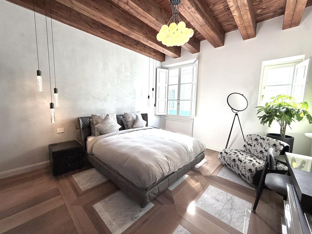Primary bedroom — original beams and marble-inlaid floor