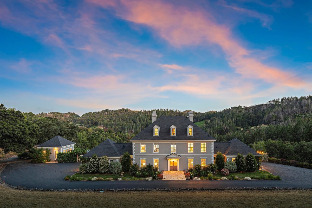 Estate exterior and pool at dusk