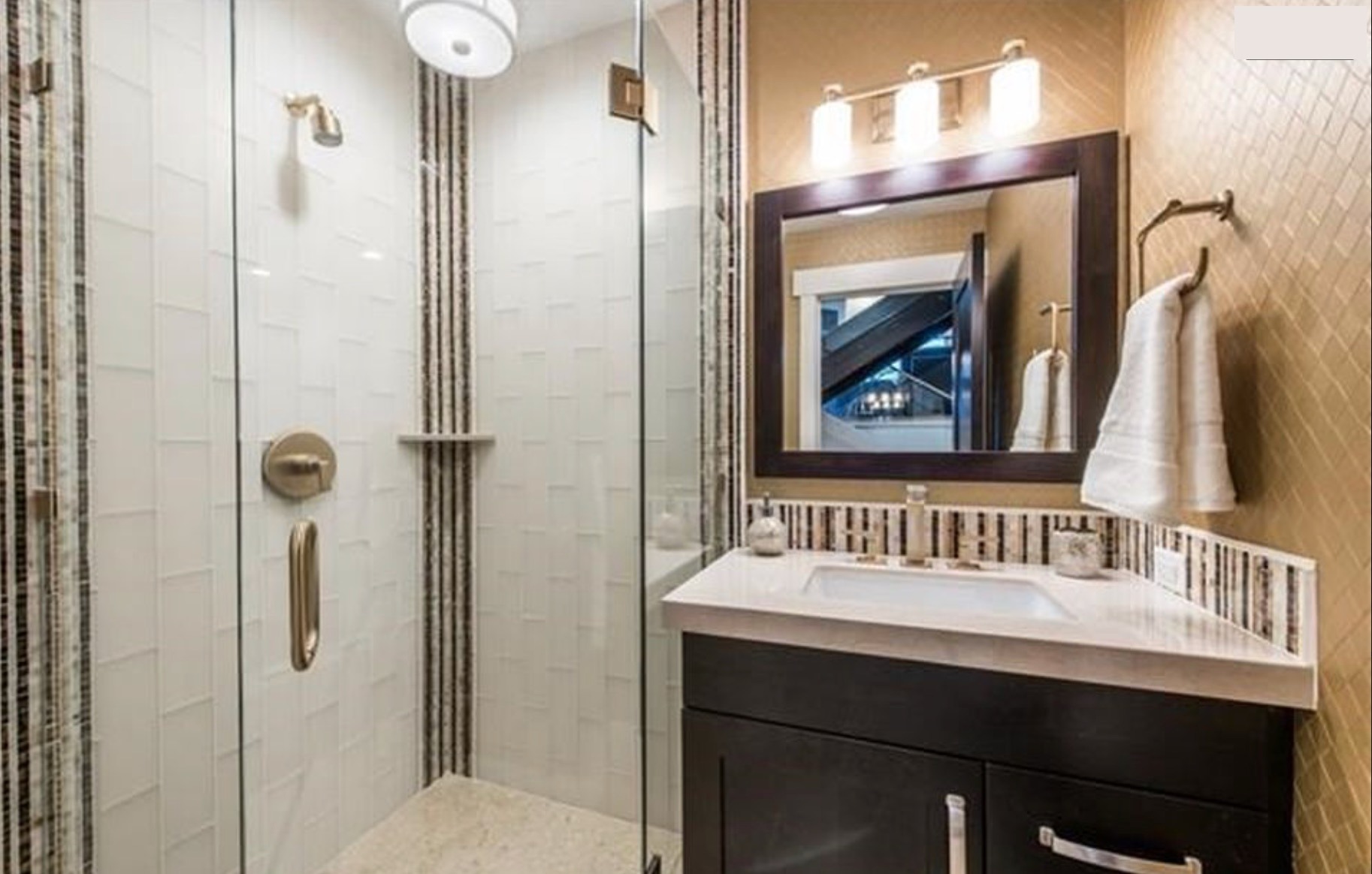 Bath — vertical white textured tile shower, dark vanity, brass fixtures