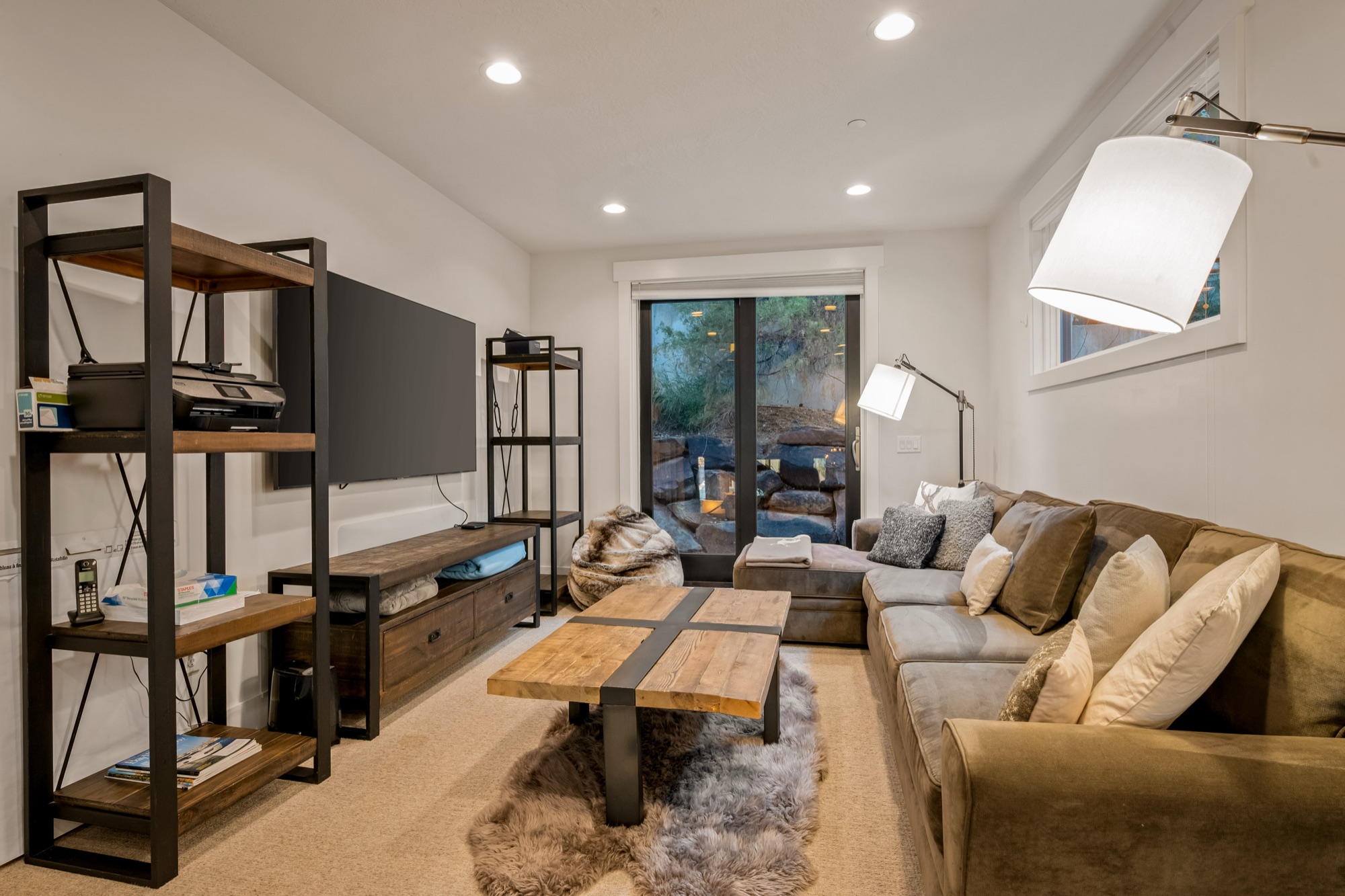 Family room with sectional and zebra rug, staircase to upper level