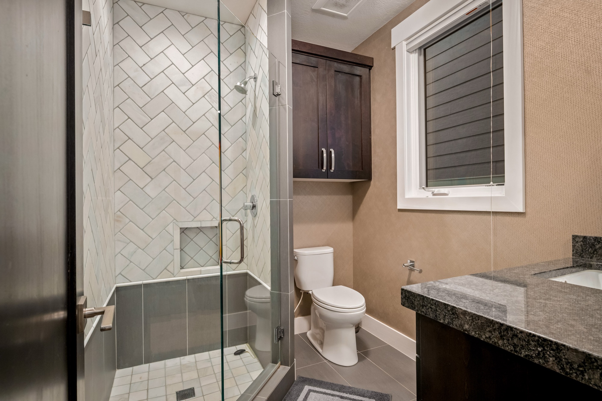 Guest bath — herringbone subway tile shower, granite vanity