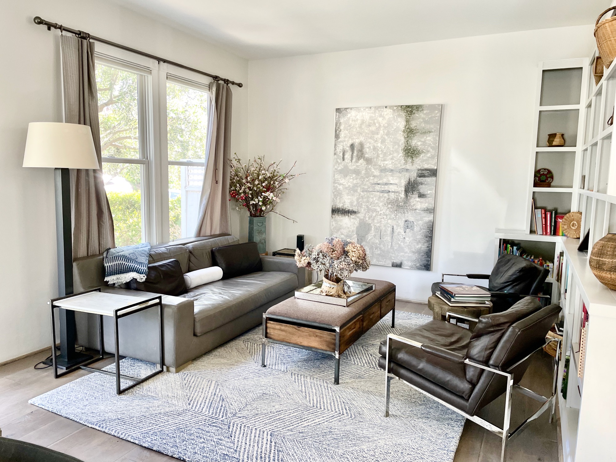 Living room — leather sofa, abstract art, bookshelves